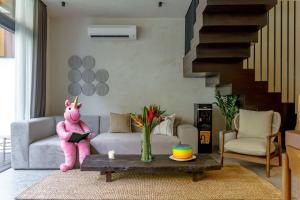 a living room with a pink stuffed animal sitting on a couch at Sunny Cuddles in Canggu