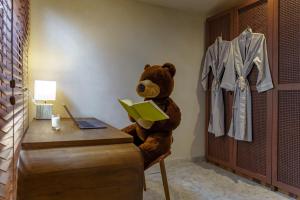 a teddy bear sitting at a desk with a book at Sunny Cuddles in Canggu