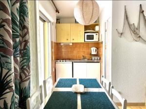 a kitchen with a table and chairs in a room at Studio cabine avec terrasse, 4 couchages, parking privé - Marseillan - FR-1-326-415 in Marseillan