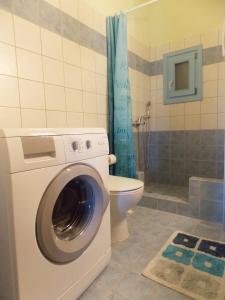 ein Badezimmer mit einer Waschmaschine und einem WC in der Unterkunft SEA VIEW in Korissia