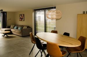 a living room with a wooden table and chairs at Bungalow 70 op Recreatiepark De Wielen in Sint Maarten