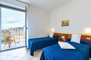2 Betten in einem Zimmer mit Balkon in der Unterkunft Appartamento Pinolo Trilo INT 9 - MyHo Casa in Alba Adriatica