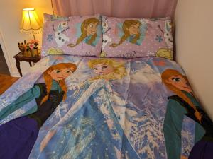 uma cama com um quadro de princesas Disney sobre ela em Sherlock's House - Two bedroom terrace 3 beds 2 sofa beds Garden Private free parking & WIFI Accessibility Contractors Family & Kids & Pet are welcome em Church Gresley