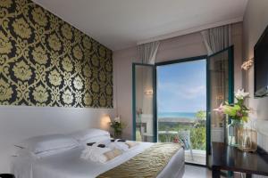 a bedroom with a bed and a large window at Hotel Villa Rosa Riviera in Rimini +37 photos