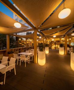 een restaurant met tafels, stoelen en verlichting bij Novotel Bucharest City Centre in Boekarest