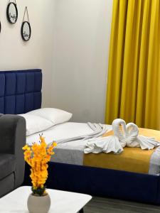 um quarto com uma cama, um sofá e uma mesa em Andor Luxury Hotel em Durrës