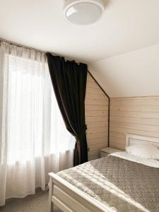 a bedroom with a bed and a window at Софія in Yasinya