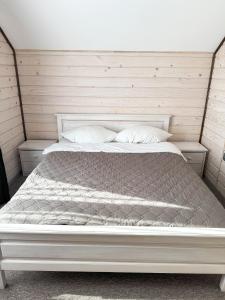 białe łóżko z 2 poduszkami w sypialni w obiekcie Софія w mieście Jasina