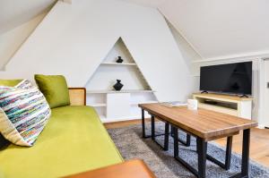 sala de estar con sofá verde y mesa en Split Level Studio at West Hampstead by Concept Apartments en Londres