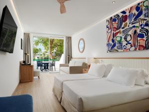 um quarto com uma cama e uma sala de estar em H10 Lanzarote Princess em Playa Blanca