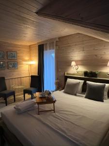 a bedroom with a large bed and a table at Agate Hotel in Ozolnieki