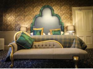 a bedroom with a large bed with a green headboard at Beaufort Hotel in Inverness