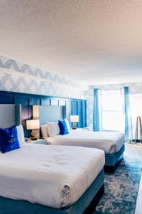 2 letti in una camera d'albergo con pareti blu di Salem Waterfront Hotel & Suites a Salem