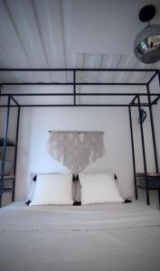 1 dormitorio con 1 cama blanca con dosel de metal en CASA V - Mizata, en Santa María Mizata