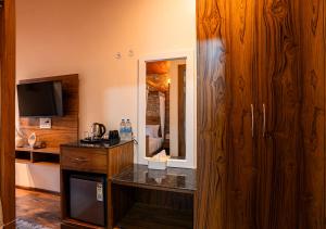 ビムタルにあるMoustache Bhimtal Luxuria, Nainitalのカウンターとテレビ付きのキッチンが備わるホテルルームです。