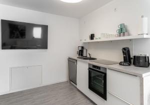 a white kitchen with a stove and a sink at Haus Himmelglück - Fewo Glück mit Terrasse & 2 Schlafzimmer in Zinnowitz