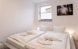 een witte slaapkamer met 2 handdoeken op een bed bij Haus Himmelglück - Fewo Glück mit Terrasse & 2 Schlafzimmer in Zinnowitz