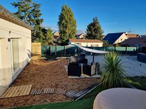 a backyard with a fire pit and a fence at Jolie Maison récente, au calme avec jardin et parking gratuit in Saint-Denis-de lʼHôtel