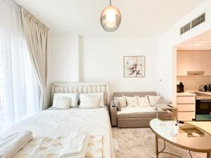 a white bedroom with a bed and a couch at Canal Front Haven 206WB12 in Abu Dhabi