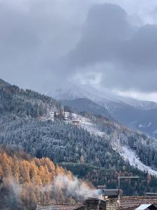 una montaña cubierta de nieve con una ciudad en una colina en Medemaistro, en Faver