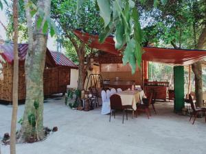a patio with a table and chairs and trees at JUNGLE AERIAL ARTS NAMASTE LA UNION Chi fan kubo 2pax in Rimus