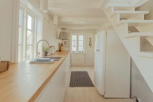 una cocina con armarios blancos y una escalera en Charming Retreat in the Heart of Tórshavn en Tórshavn