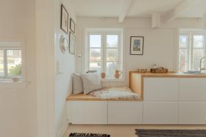 a kitchen with white cabinets and a bench with pillows at Charming Retreat in the Heart of Tórshavn in Tórshavn