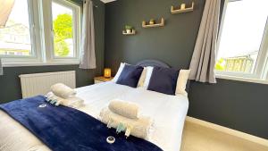 a bedroom with a large bed with blue walls and windows at Huge Family House - Free Parking - Central Harrogate in Harrogate