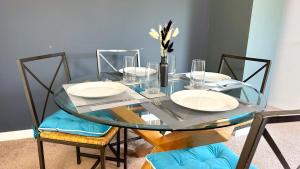 a glass table with chairs and plates on it at Huge Family House - Free Parking - Central Harrogate in Harrogate