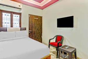 a bedroom with a bed and a chair and a television at Prakash landmark in Varanasi