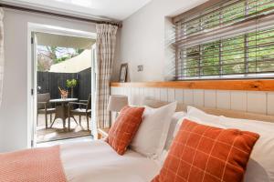 a bedroom with a bed with orange and white pillows at The Bickley Mill in Newton Abbot