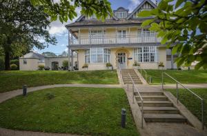 a large yellow house with stairs in front of it at Northgate House in Buckfastleigh