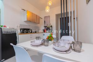 a kitchen with a white table and white chairs at Comfy Studio Room by Moowin in Perai