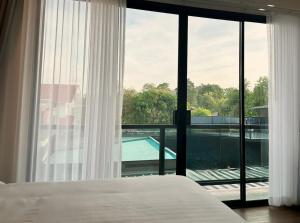 a bedroom with a bed and a view of a pool at Arun Heaven Bangkok in Bangkok Noi