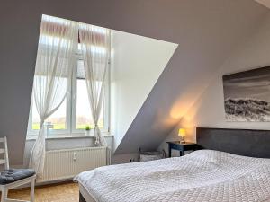 a bedroom with a bed and a large window at Sünnslag Ostsee-Perle Wohnung 044 in Boltenhagen