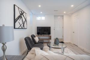 a living room with a couch and a tv at The Oasis in Bowmanville