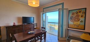 sala de estar con mesa de comedor y TV en Miramare Apartment, en Acquedolci