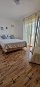 a bedroom with a bed and a wooden floor at Sunce 2 in Vrbnik