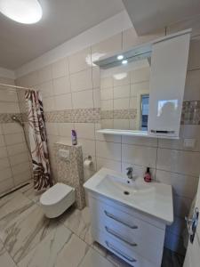 a bathroom with a sink and a toilet and a mirror at Sunce in Vrbnik