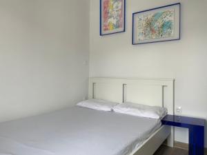 Bett in einem Zimmer mit zwei Bildern an der Wand in der Unterkunft roofgarden apartment close subway station in Athen