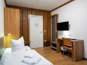 una camera d'albergo con letto e scrivania con computer di Gästehaus Nikolai a Erfurt