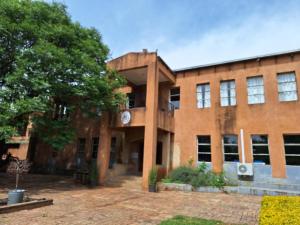 a brick building with a tree in front of it at Bosheuvel Country Estate in Muldersdrift