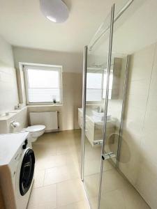 a bathroom with a shower and a washing machine at Schwabe, Ferienwohnung in Schneverdingen