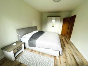 a bedroom with a large bed and a wooden floor at Schwabe, Ferienwohnung in Schneverdingen