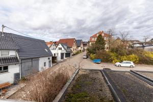 a street in a town with houses and a car at Apartmenthaus Ferienwohnungen Sila in Weinstadt
