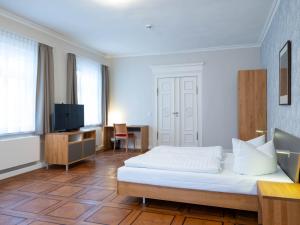 una camera d'albergo con un letto e una televisione di Gästehaus Nikolai a Erfurt