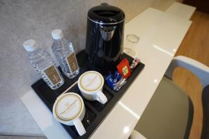 ein Tablett mit 2 Flaschen Wasser und einer Kaffeemaschine in der Unterkunft Hotel The Landmark Chhatarpur in Chhatarpur