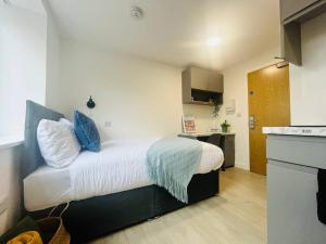 a small bedroom with a bed and a kitchen at Quaint & Cosy Studio in Stretford in Manchester