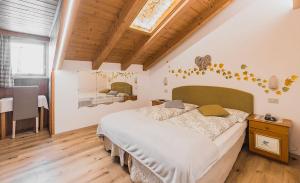 a bedroom with a large bed and a dining room at Hotel Aida in Pozza di Fassa