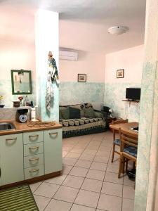 Residence Olimpo في سانتا تيريزا غالّورا: مطبخ وغرفة معيشة مع أريكة في الخلفية